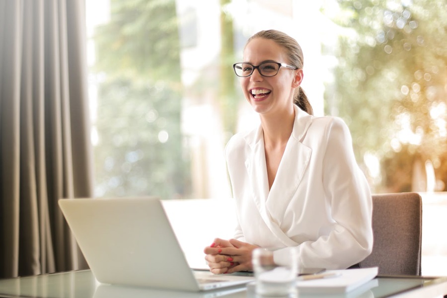 rire-femme-d-affaires-travaillant-au-bureau-avec-ordinateur-portable